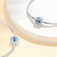 Bracelet argenté élégant avec charm œil de protection bleu sur boucle ronde texturée.