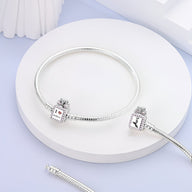 Bracelet fin en argent avec pendentifs carrés personnalisables sur fond blanc circulaire.