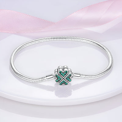 Bracelet pour charm en argent avec fermoir en forme de trèfle orné de pierres vertes.