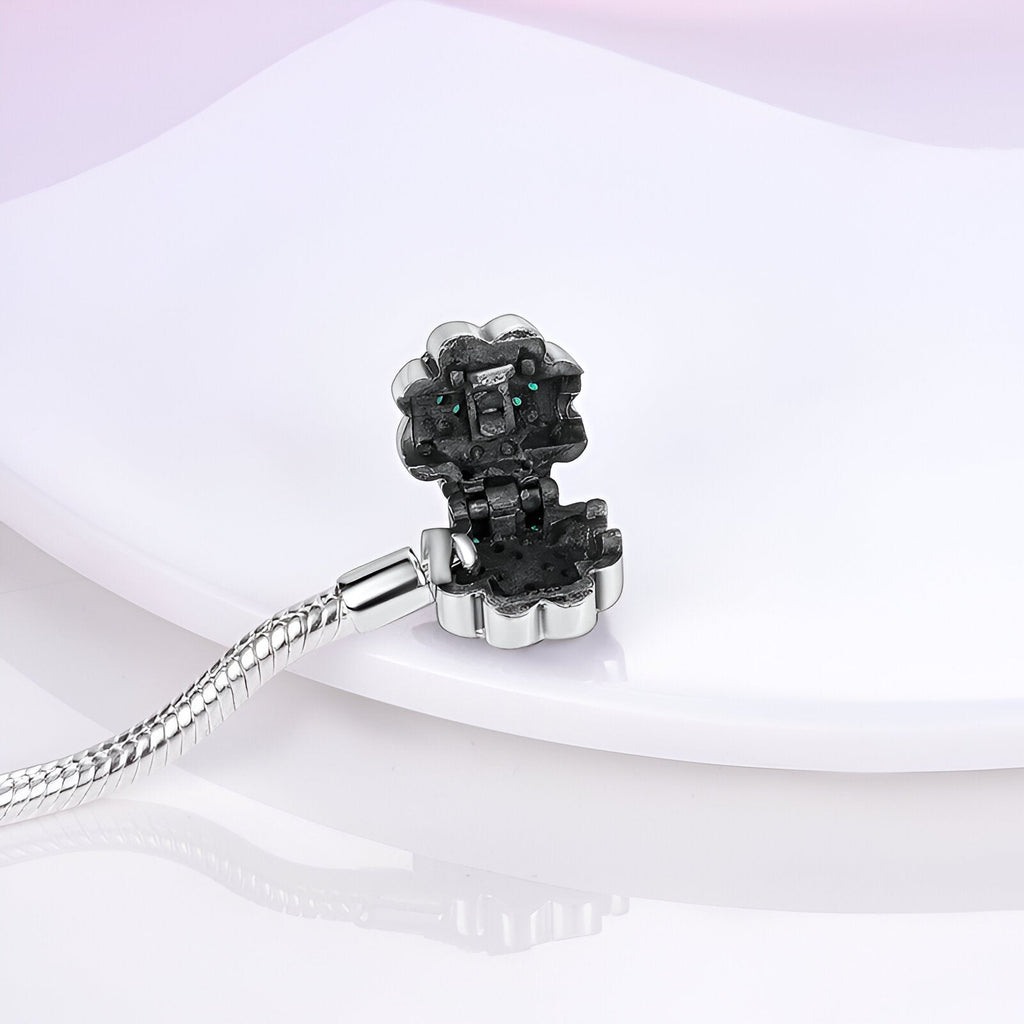 Bracelet en argent avec charm en forme de fleur noire, détail brillant et chaîne serpent fine.