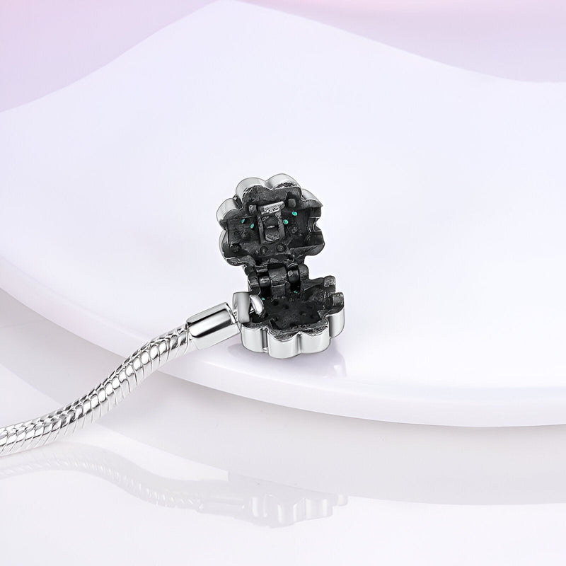 Bracelet en argent avec charm en forme de fleur noire, détail brillant et chaîne serpent fine.