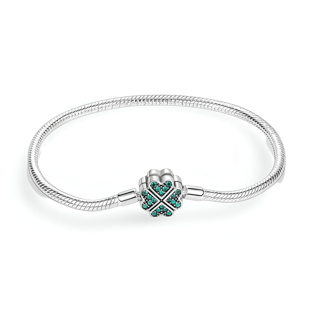 Bracelet argenté serpent avec charm en forme de trèfle orné de pierres vertes.