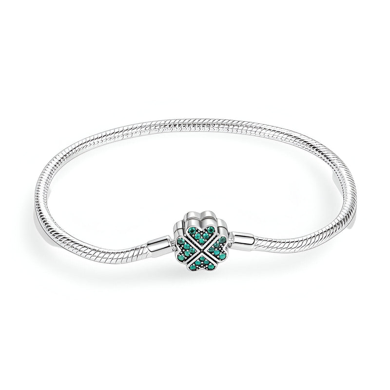Bracelet argenté serpent avec charm en forme de trèfle orné de pierres vertes.