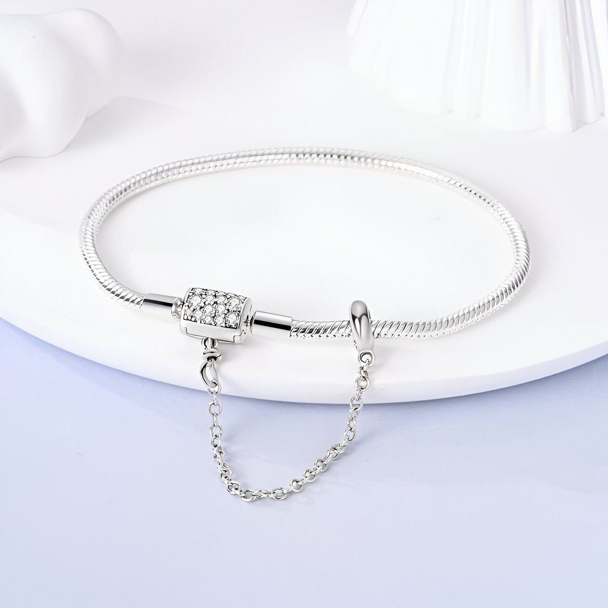 Bracelet pour charm en argent avec chaîne de sécurité et fermoir à motifs gravés.