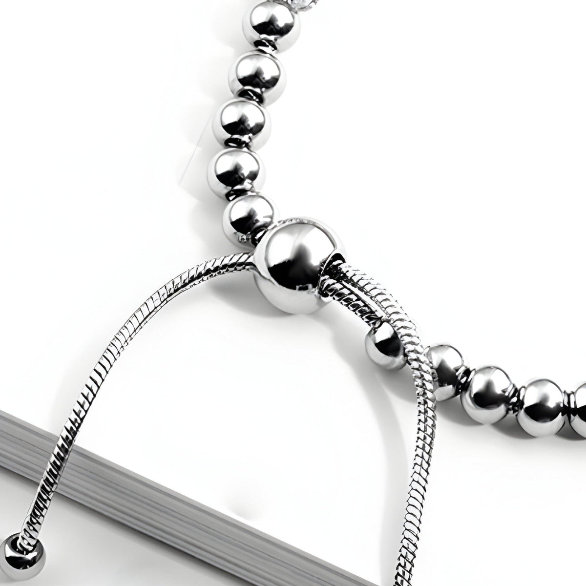 Bracelet femme en titane argenté avec perles rondes et détail coulissant lisse.