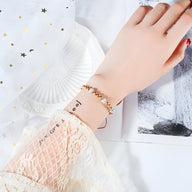 Bracelet femme en titane or rosé avec perles blanches et zircones scintillantes.