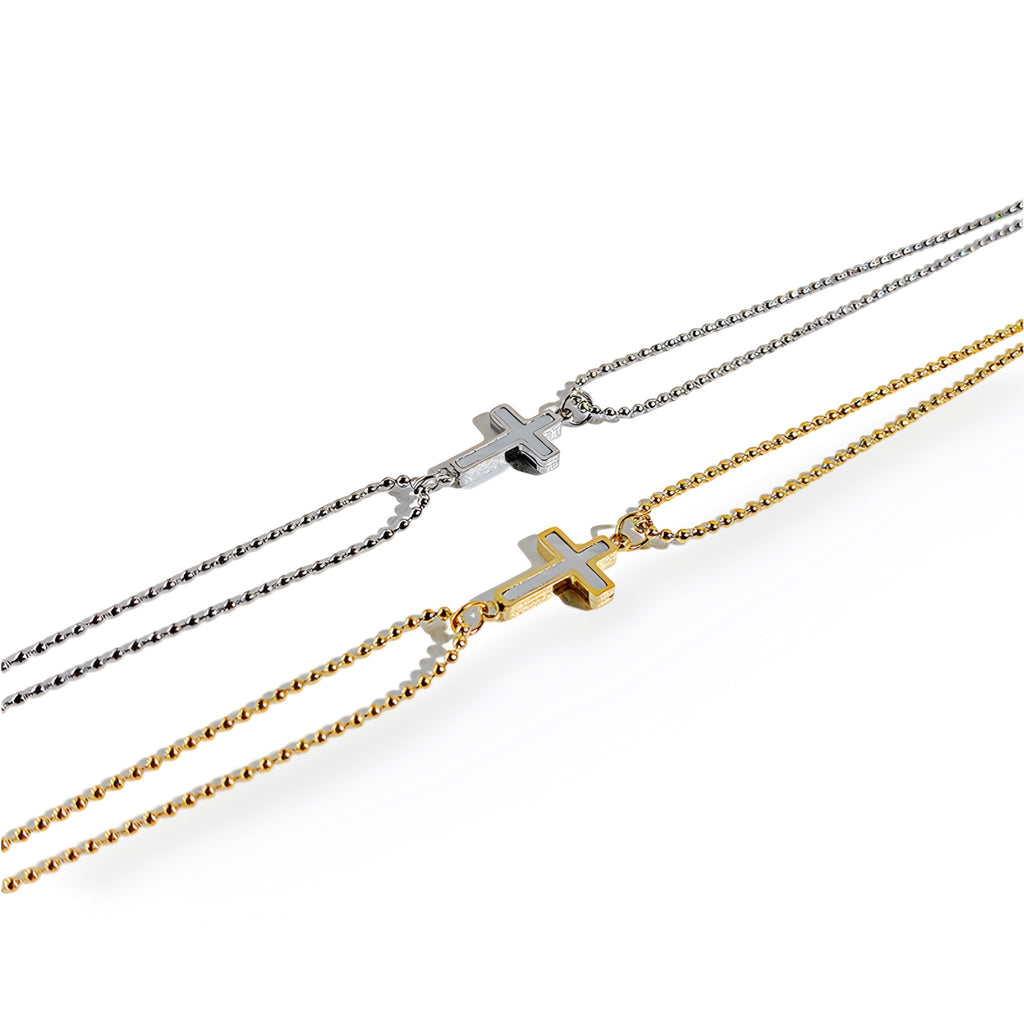 Bracelet femme chaîne fine en acier inoxydable avec charm croix, coloris or et argent.