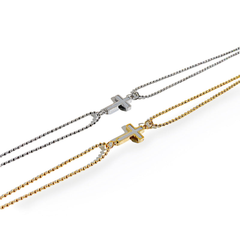 Bracelet femme chaîne fine en acier inoxydable avec charm croix, coloris or et argent.