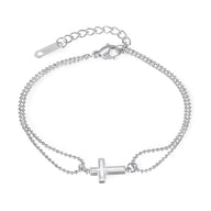 Bracelet double chaîne fine en acier inoxydable argent avec charm croix ajourée.