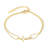 Bracelet double chaîne fine en acier inoxydable doré avec charm croix creuse au centre.