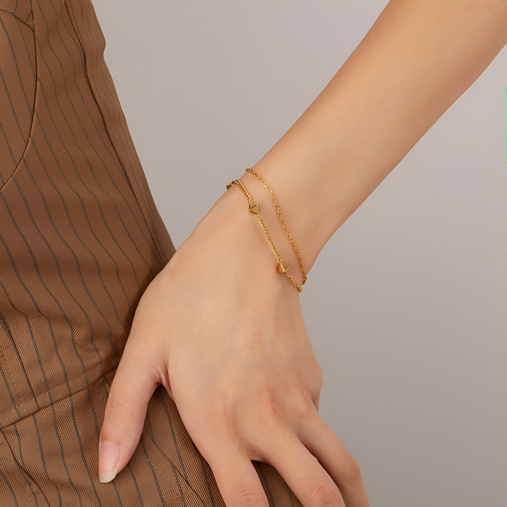 Bracelet pour femme en acier inoxydable doré aux formes géométriques fines et élégantes.