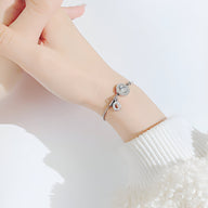 Bracelet femme en acier argenté avec charms chiffres romains en verre, style élégant et délicat.