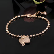 Bracelet femme or rosé en acier inoxydable à billes avec charm double cœur gravé modèle Rita.