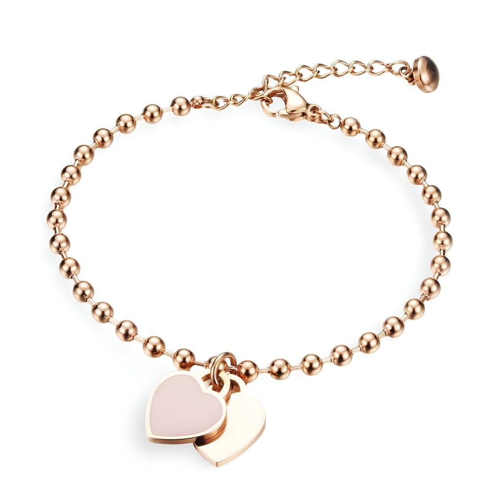 Bracelet en acier inoxydable or rosé avec chaînette à perles et double pendentif cœur lisse.