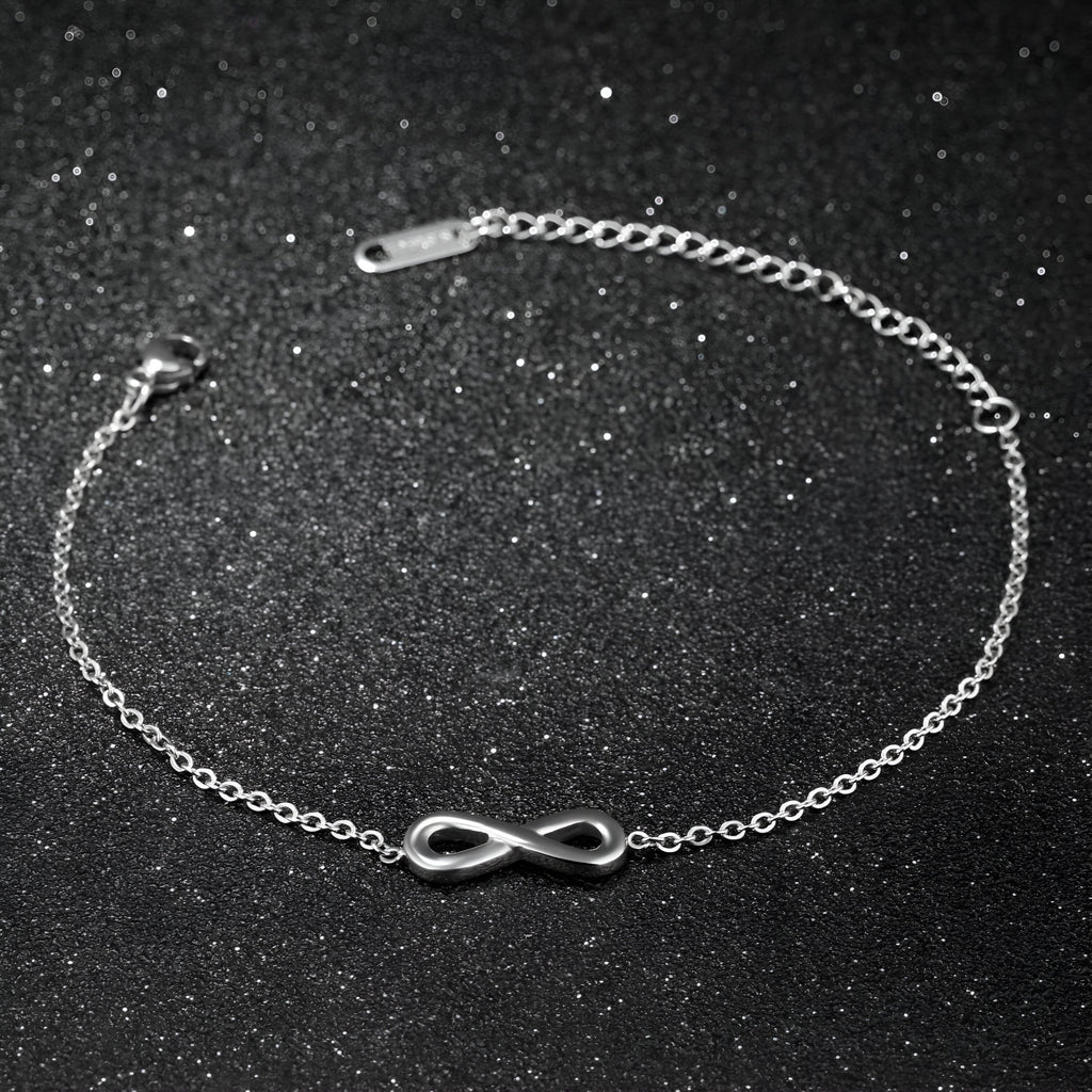 Bracelet fin en acier inoxydable argenté avec un charm infini lisse et délicat.