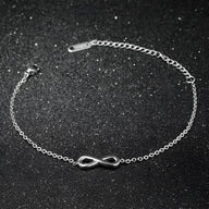 Bracelet fin en acier inoxydable argenté avec un charm infini lisse et délicat.