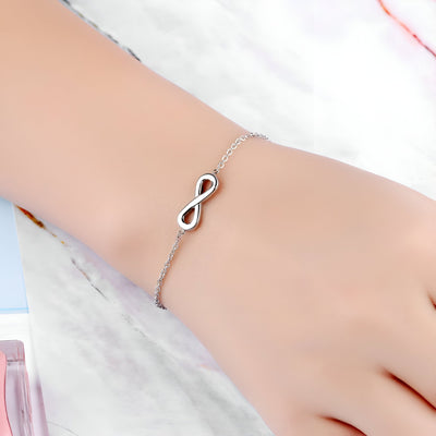 Bracelet fin en acier inoxydable argenté avec petit charm infini sur une chaîne délicate.