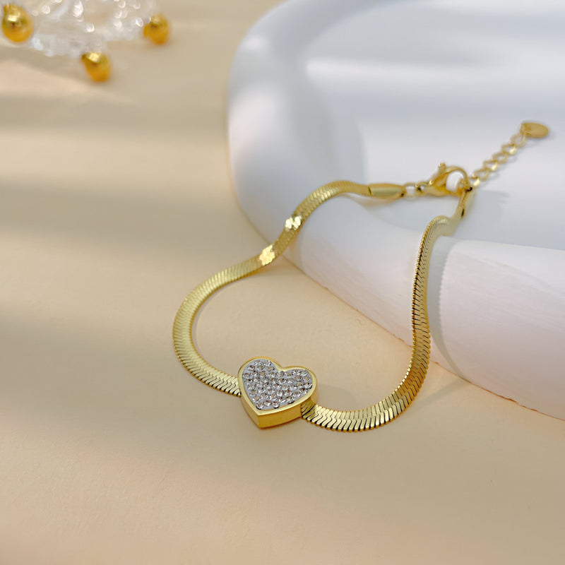 Bracelet or en acier inoxydable avec cœur serti de zirconium sur chaîne fine plate.