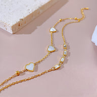 Bracelet femme en acier inoxydable doré avec cœurs blancs et zirconiums brillants.