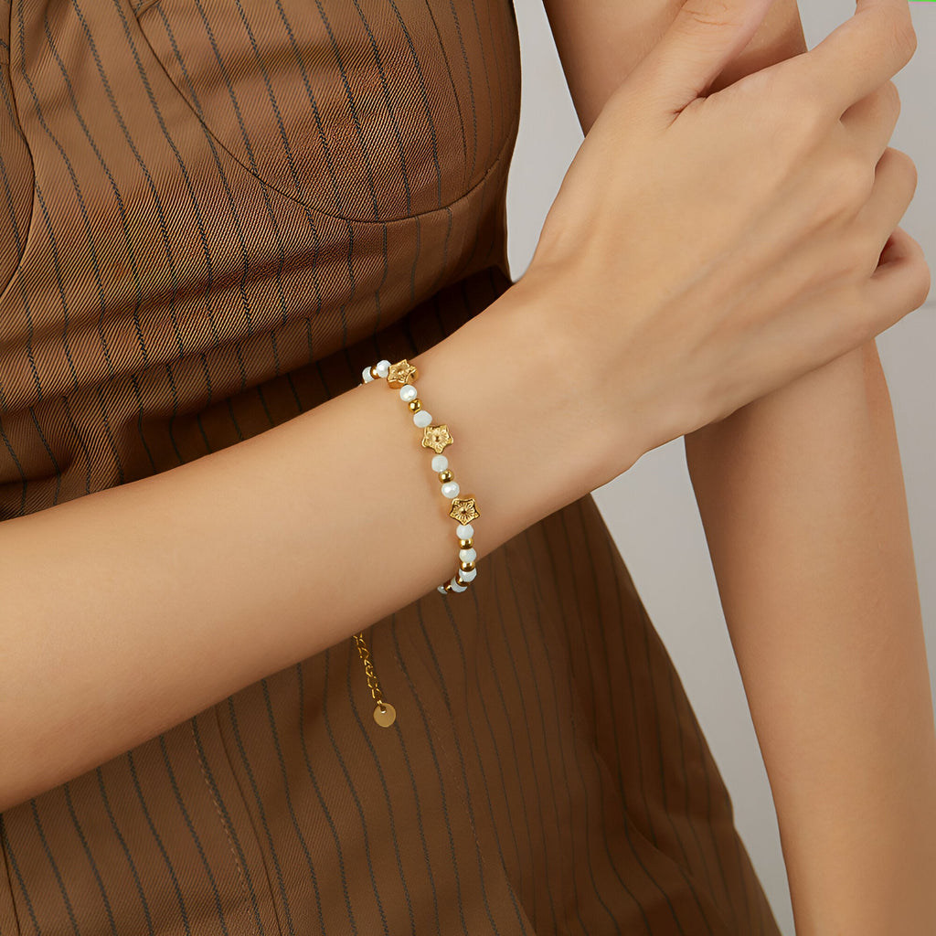 Bracelet femme en acier doré avec perles d’amazonite et charms étoiles raffinés.