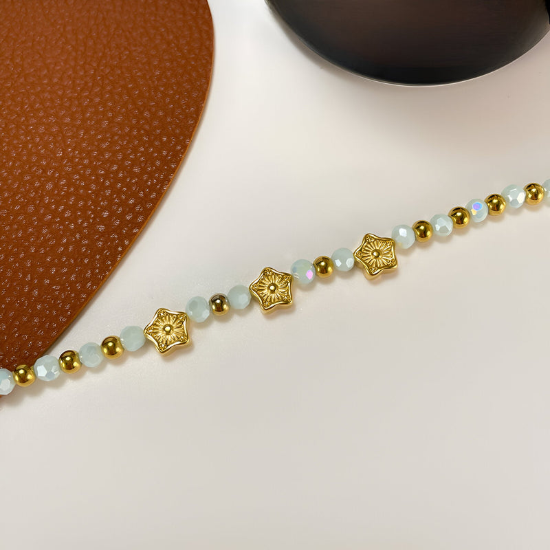 Bracelet femme or en acier inoxydable avec perles d'amazonite et charms étoiles dorés.