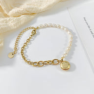 Bracelet femme moitié perles blanches, moitié chaîne acier doré avec charm smiley rond doré.