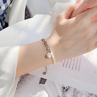 Bracelet femme en acier inoxydable argenté avec perles blanches et pendentif smiley rond.