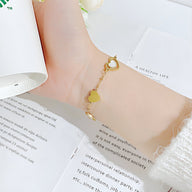 Bracelet fin en acier inoxydable doré avec cœurs alternés, fermeture à mousqueton.