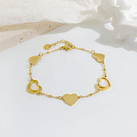 Bracelet femme en acier inoxydable doré avec cœurs pleins et ajourés alternés.