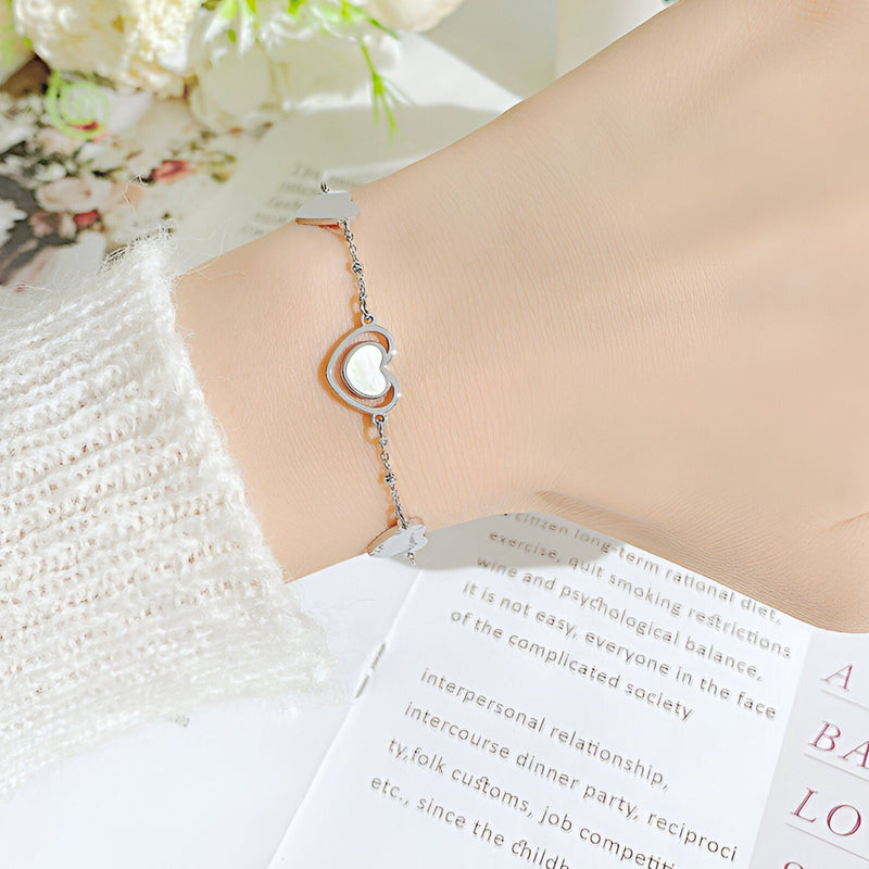 Bracelet femme en acier inoxydable argenté avec cœurs alternés et finition brillante.