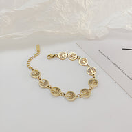 Bracelet femme or en acier inoxydable avec multiples pendentifs arbres de vie ajourés en cercles-linked.