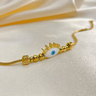 Bracelet doré pour femme en acier inoxydable avec œil bleu central et motif rayonnant.