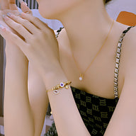 Bracelet or en acier avec œil violet de protection, style délicat pour femme.