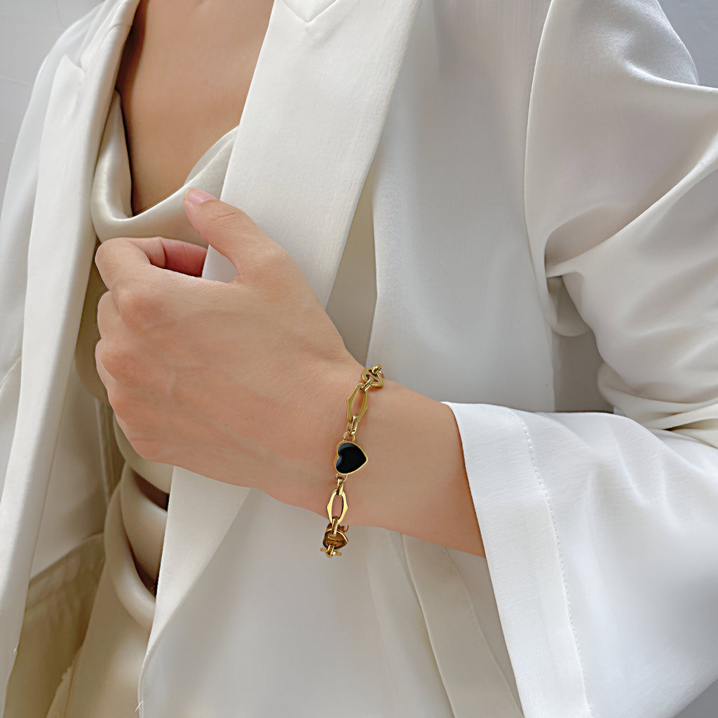 Bracelet doré en acier inoxydable avec pendentif cœur noir, style élégant féminin.