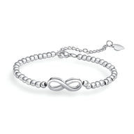 Bracelet femme en acier inoxydable argenté avec perles rondes et motif infini au centre.