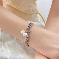 Bracelet pour femme en acier inoxydable argenté avec perles pendantes raffinées.