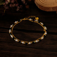Bracelet femme en acier inoxydable doré avec pierres naturelles blanches et perles élégantes.