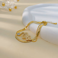 Bracelet serpent glissant en acier inoxydable doré avec détail tressé et fermoir réglable.