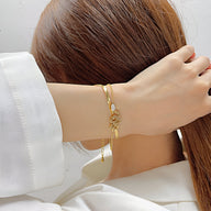 Bracelet serpent glissant en acier inoxydable doré porté au poignet, design fin et élégant.