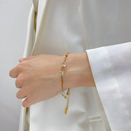 Bracelet fin en acier inoxydable doré avec cubes d'oxyde de zirconium sur poignet femme.