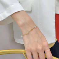 Bracelet femme en acier inoxydable doré avec cubes d'oxyde de zirconium délicats.