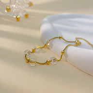 Bracelet doré pour femme en acier inoxydable avec cubes transparents sertis d'oxyde de zirconium.