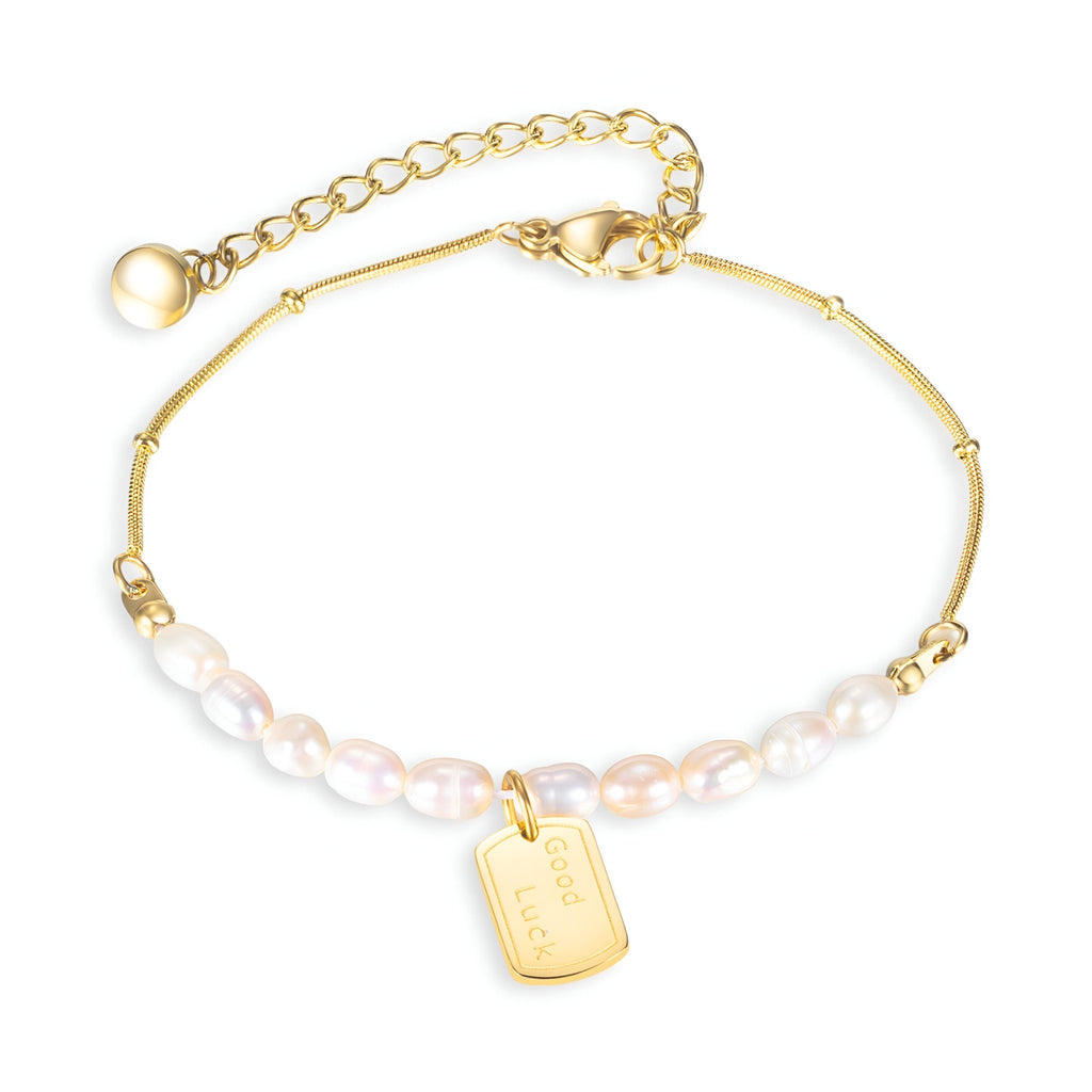 Bracelet femme en acier inoxydable or orné de perles blanches et médaille rectangulaire gravée.