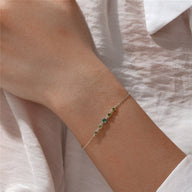 Bracelet fin en argent sterling avec petits zircons verts sertis sur chaîne délicate.