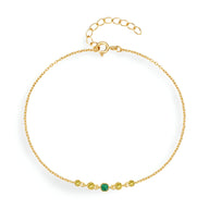 Bracelet fin en argent doré avec petites étoiles et zircon vert central.