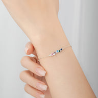 Bracelet fin en argent sterling avec zircons colorés multicolores élégants, porté au poignet féminin.