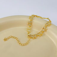Bracelet femme en cuivre doré avec papillons sertis de zirconiums scintillants.