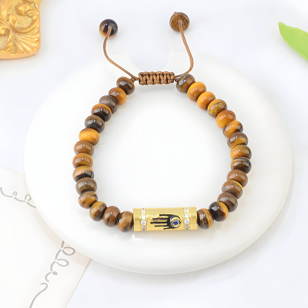 Bracelet femme en perles oeil de tigre marron avec pendentif main égyptienne dorée ajustable.