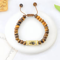Bracelet femme en perles oeil de tigre marron avec pendentif main égyptienne dorée ajustable.