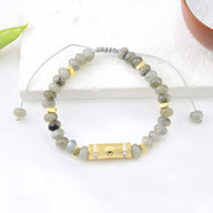 Bracelet femme pierre de lune gris perles rondes avec œil central doré et détail noir.